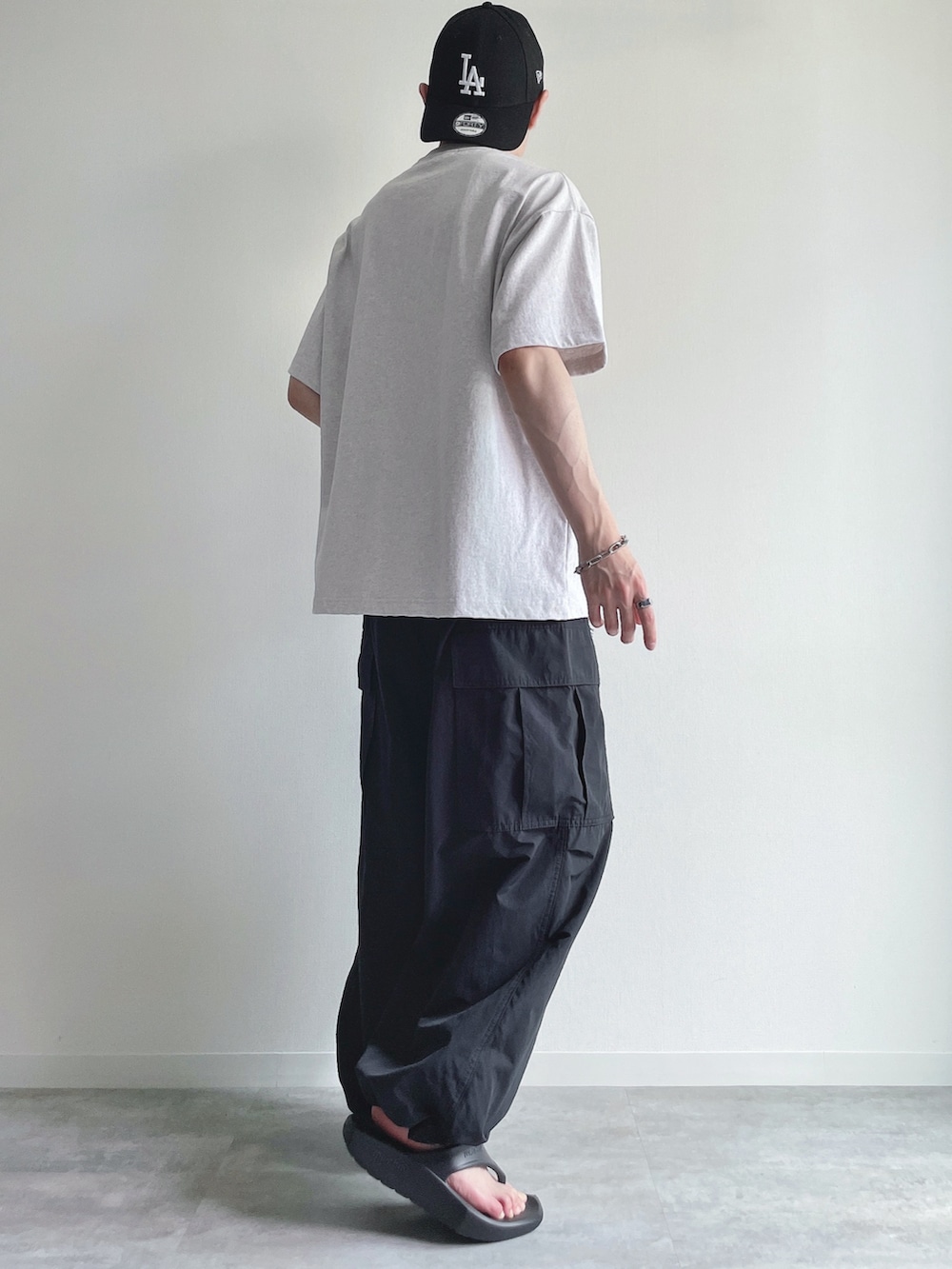 グレー系のTシャツ/カットソー、ブラック系のカーゴパンツ、ブラック系のサンダルを着用したメンズの夏コーディネートの4枚目の写真