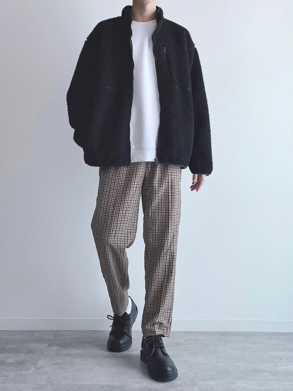 ブラック系のジャケット/アウター、ホワイト系のトップス、ブラウン系のスラックスを着用したメンズの冬コーディネートの2枚目の写真