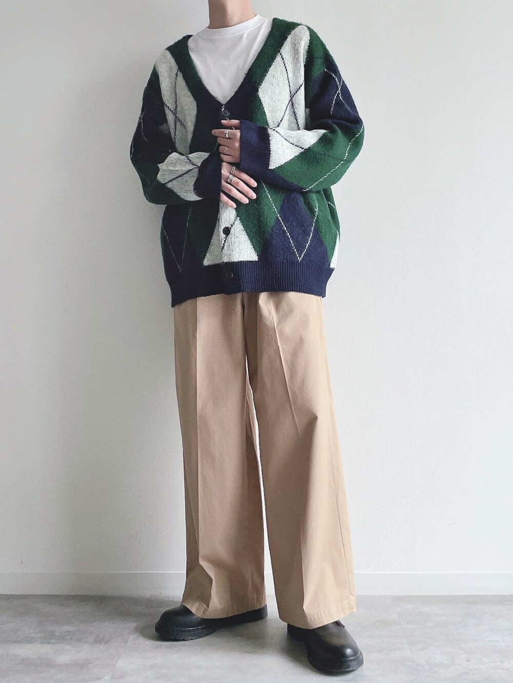 グリーン系のカーディガン/ボレロ、ホワイト系のTシャツ/カットソー、ベージュ系のチノパンツを着用したメンズの冬コーディネートの5枚目の写真