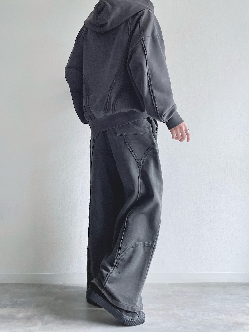 グレー系のパーカー、グレー系のスウェットパンツ、ホワイト系のタンクトップを着用したメンズの春コーディネートの4枚目の写真