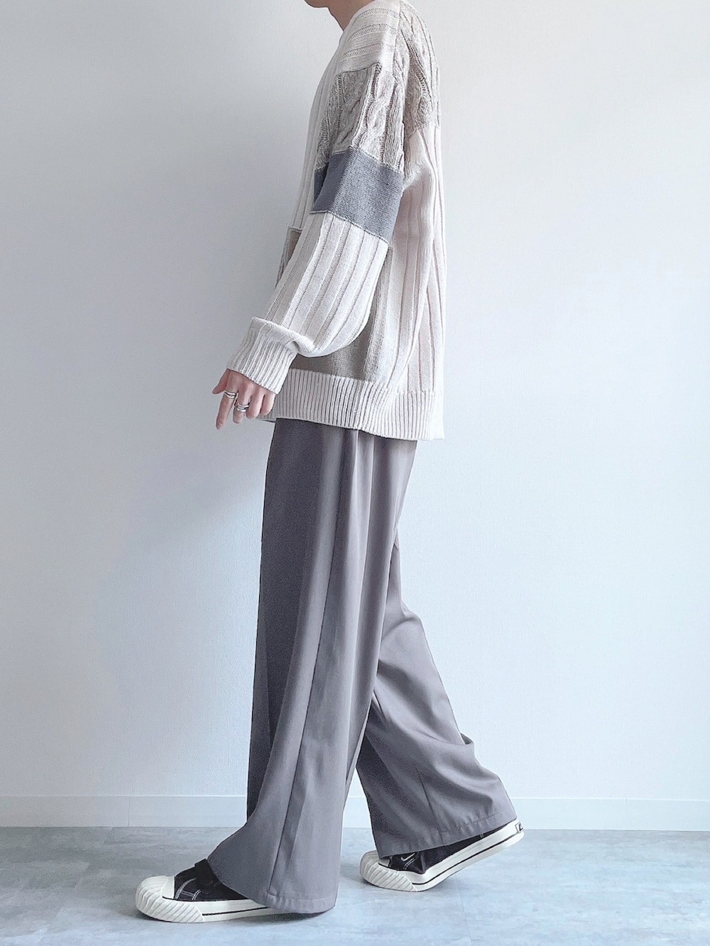 ホワイト系のニット/セーター、ベージュ系のスラックス、ブラウン系のスニーカーを着用したメンズの冬コーディネートの2枚目の写真