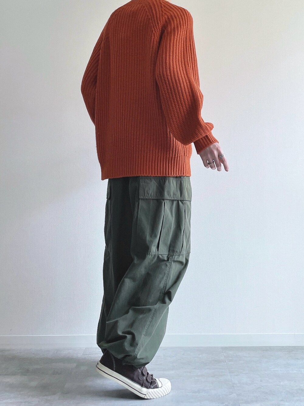 オレンジ系のトップス、グリーン系のカーゴパンツ、ブラウン系のスニーカーを着用したメンズの冬コーディネートの4枚目の写真