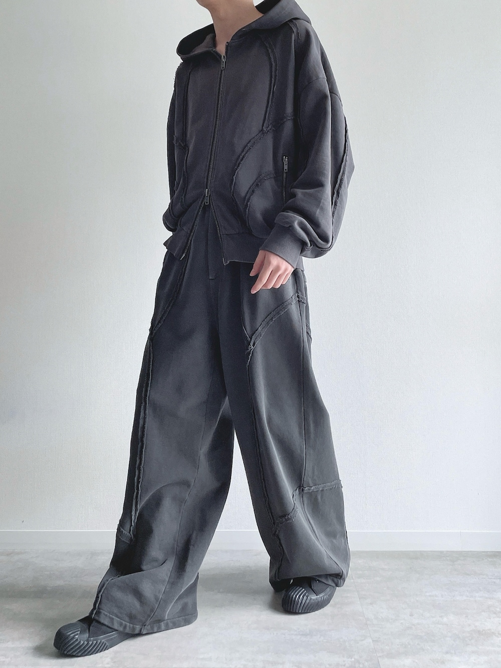 グレー系のパーカー、グレー系のスウェットパンツ、ホワイト系のタンクトップを着用したメンズの春コーディネートの5枚目の写真