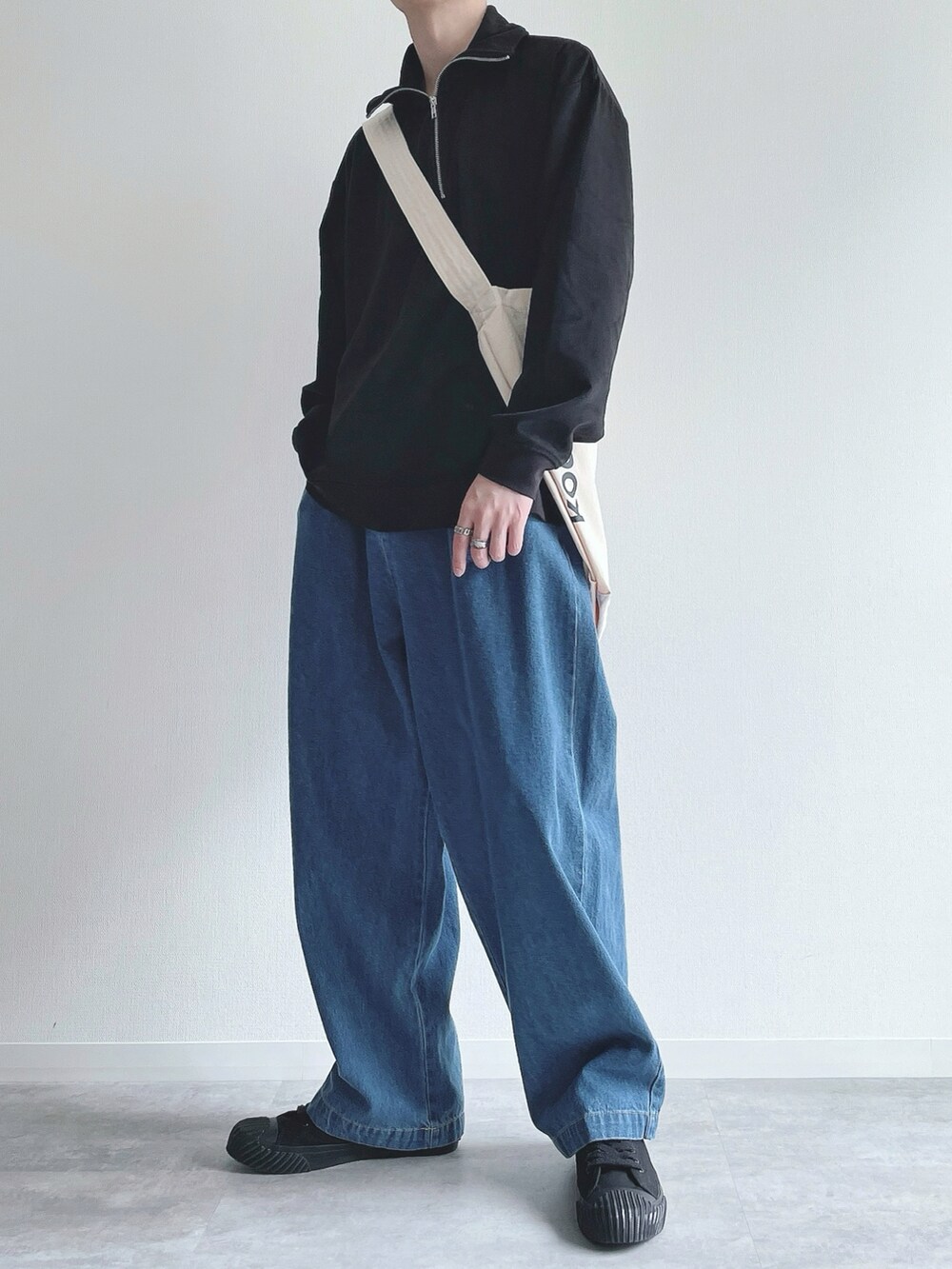 ブラック系のスウェット、ブルー系のデニムパンツ、ブラック系のスニーカーを着用したメンズの秋コーディネートの3枚目の写真