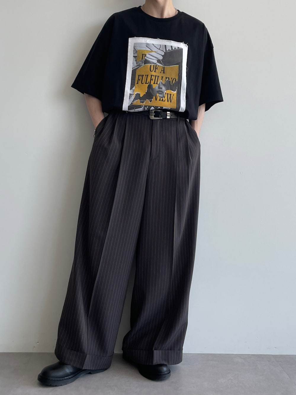 グレー系のスラックス、ブラック系のTシャツ/カットソー、ブラック系のシューズを着用したメンズの夏コーディネートの4枚目の写真