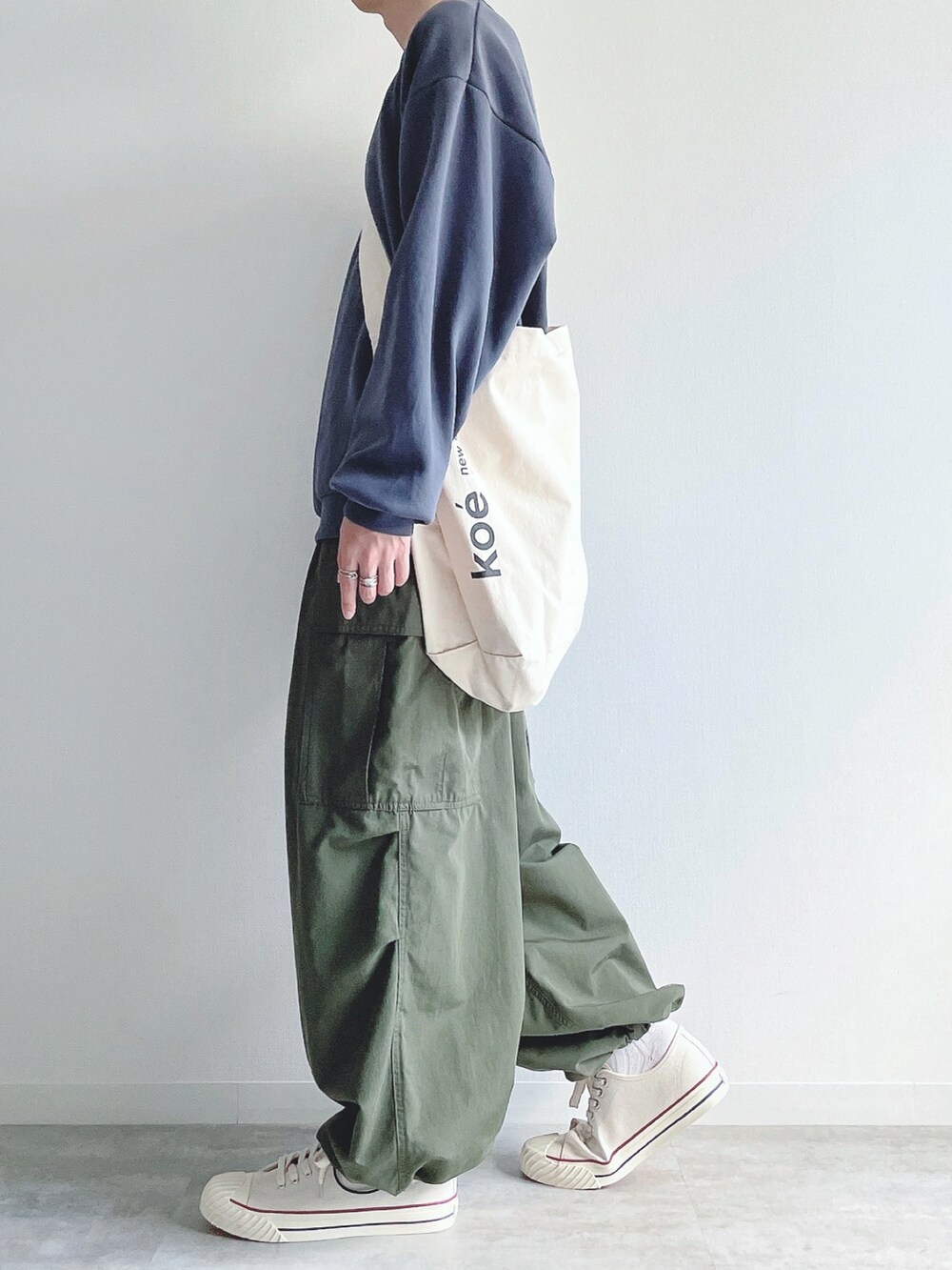 ブルー系のトップス、グリーン系のカーゴパンツ、ホワイト系のスニーカーを着用したメンズの秋コーディネートの3枚目の写真