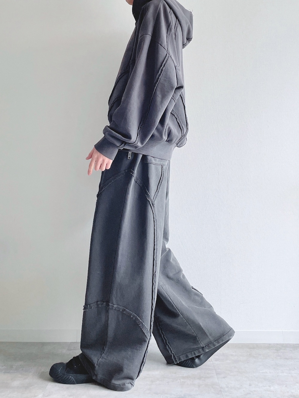 グレー系のパーカー、グレー系のスウェットパンツ、ホワイト系のタンクトップを着用したメンズの春コーディネートの2枚目の写真