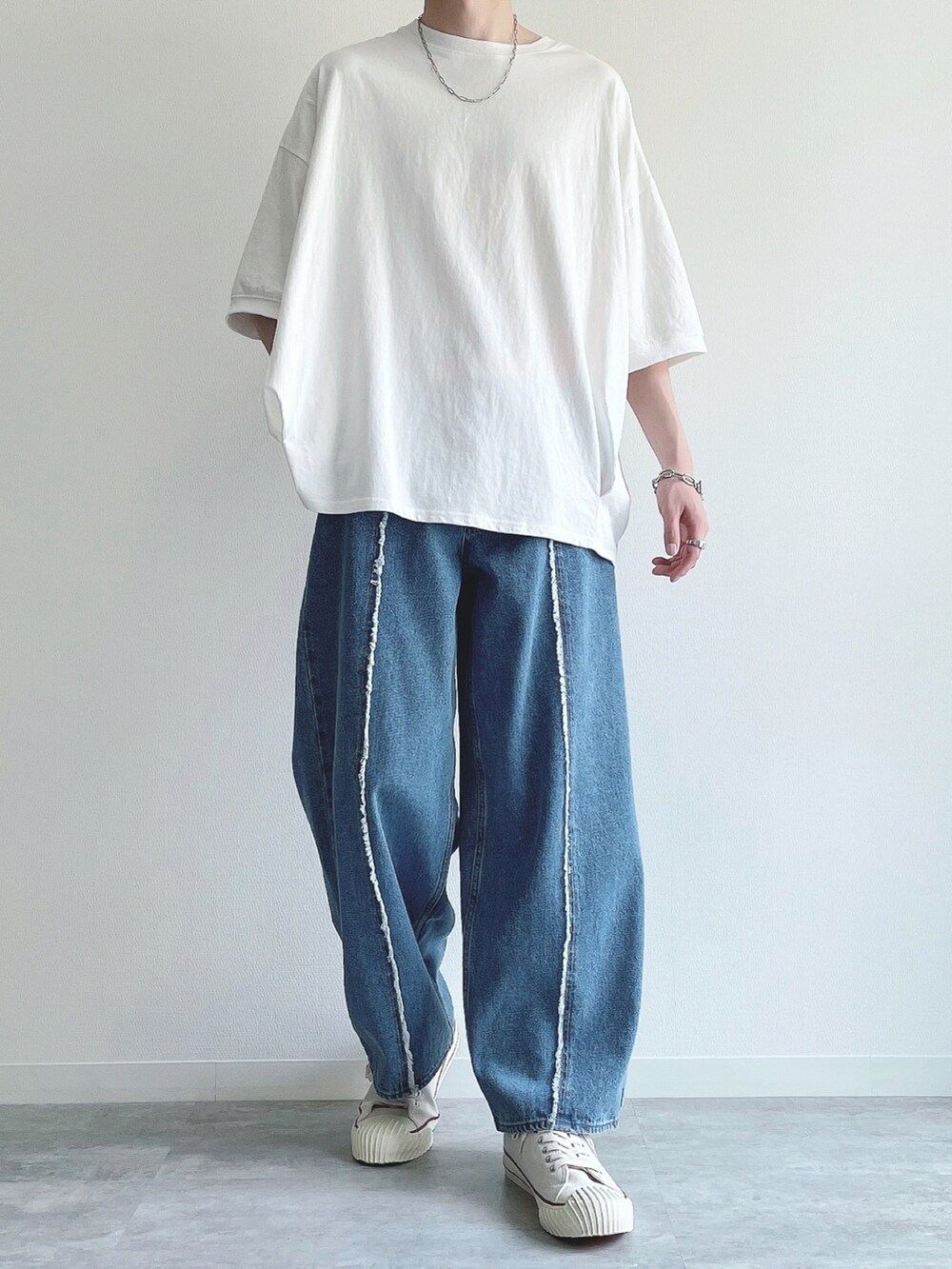 ホワイト系のTシャツ/カットソー、ブルー系のデニムパンツ、ホワイト系のスニーカーを着用したメンズの春コーディネートの2枚目の写真