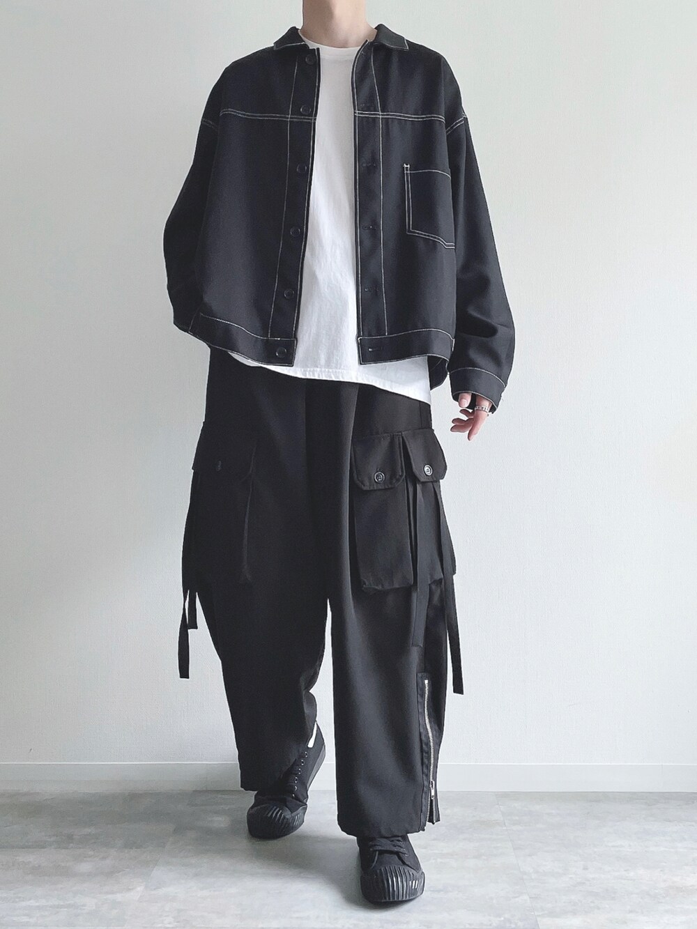 ブラック系のブルゾン、ホワイト系のTシャツ/カットソー、ブラック系のカーゴパンツを着用したメンズの秋コーディネートの2枚目の写真