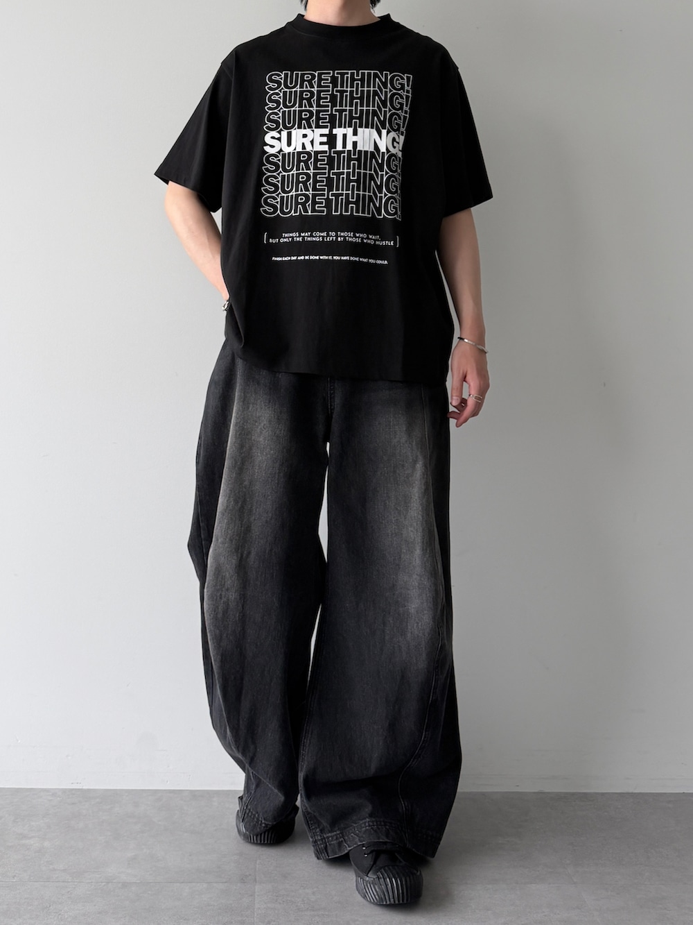 ブラック系のデニムパンツ、ブラック系のTシャツ/カットソー、ブラック系のスニーカーを着用したメンズの春コーディネートの2枚目の写真