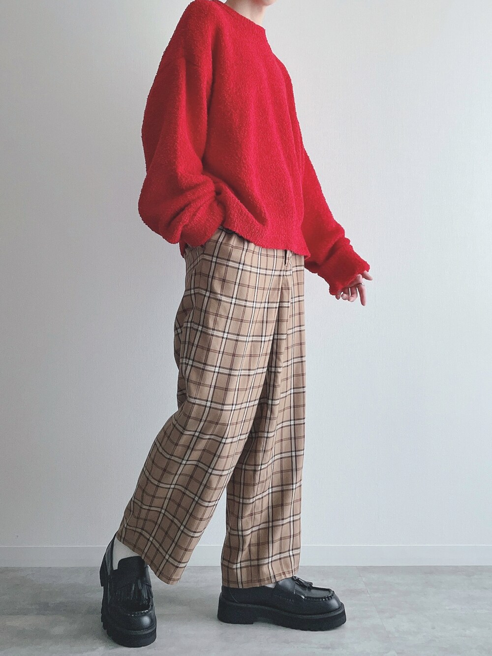 レッド系のニット/セーター、ベージュ系のその他パンツ、ブラック系のローファーを着用したメンズの秋コーディネートの5枚目の写真