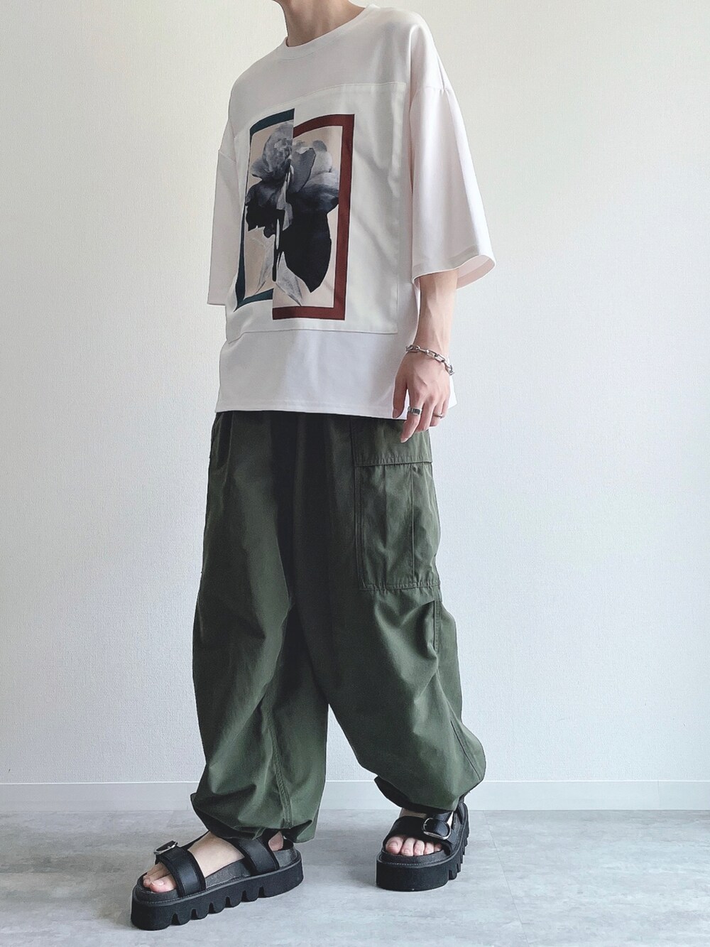 ホワイト系のTシャツ/カットソー、グリーン系のカーゴパンツ、ブラック系のサンダルを着用したメンズの夏コーディネートの5枚目の写真
