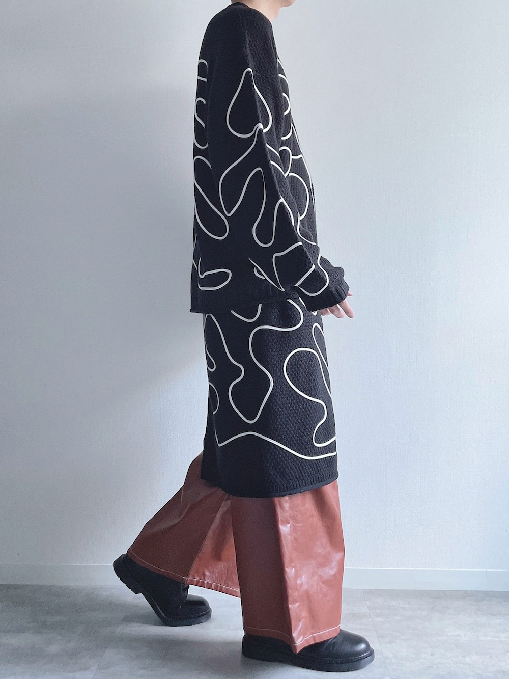 ブラック系のニット/セーター、ブラック系のスカート、ブラウン系のその他パンツを着用したメンズの冬コーディネートの2枚目の写真