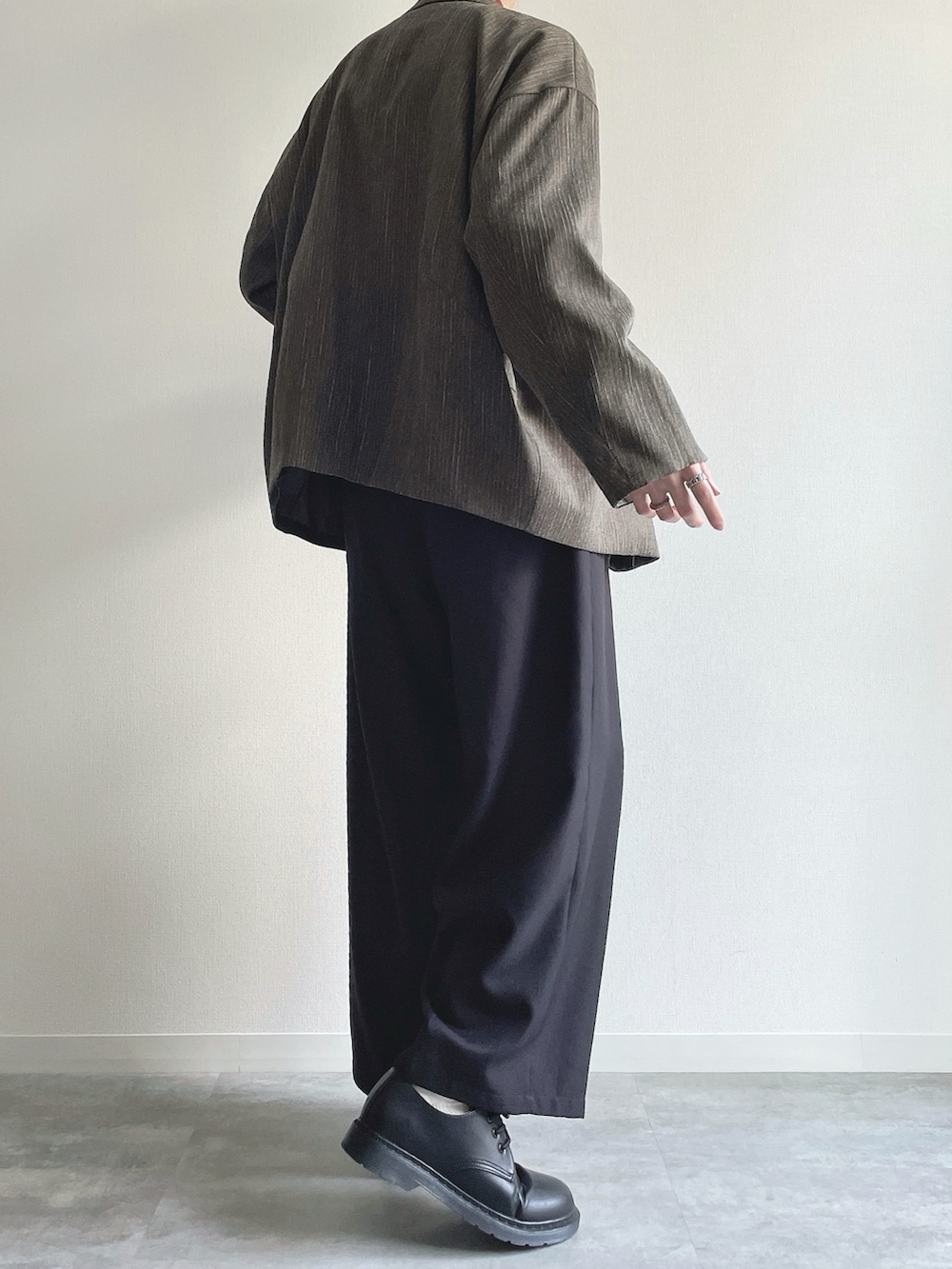 グリーン系のテーラードジャケット、レッド系のニット/セーター、ブラック系のスラックスを着用したメンズの冬コーディネートの4枚目の写真