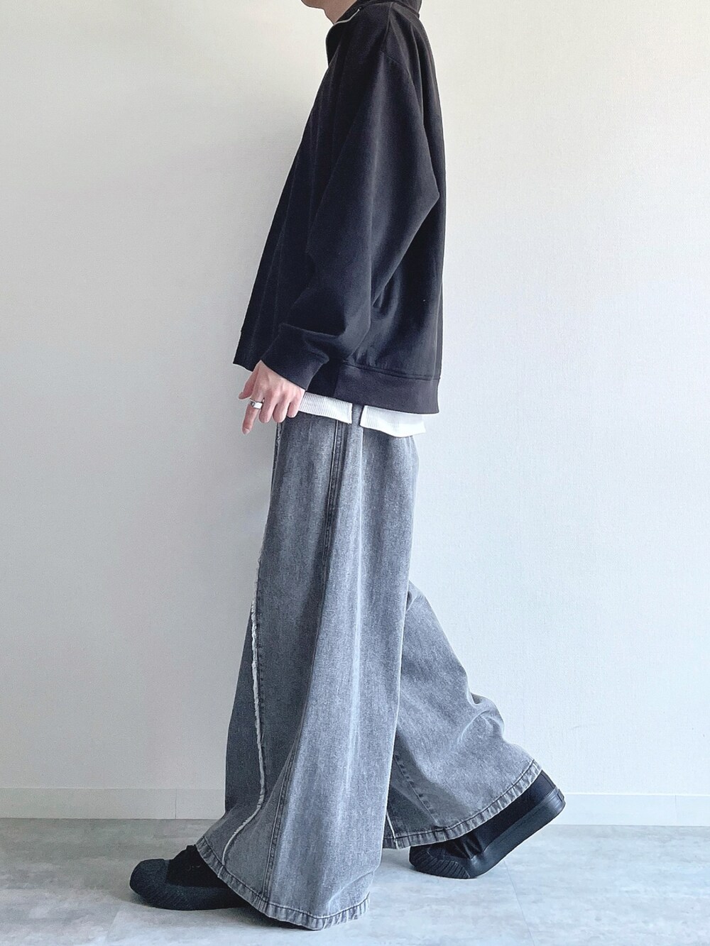 ブラック系のスウェット、ホワイト系のタンクトップ、グレー系のデニムパンツを着用したメンズの春コーディネートの3枚目の写真