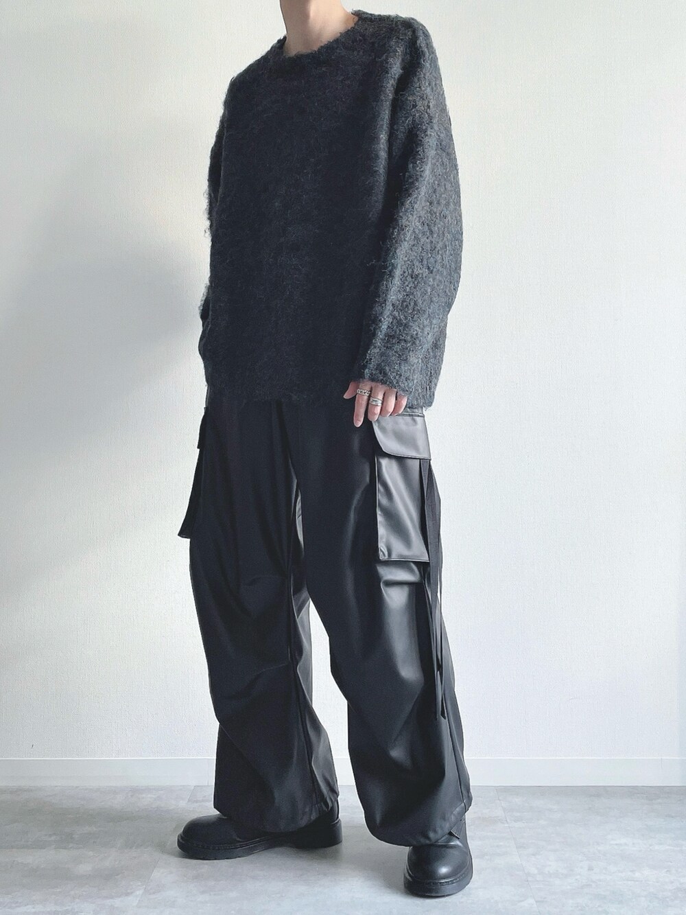 ブルー系のニット/セーター、ブラック系のカーゴパンツ、ブラック系のシューズを着用したメンズの冬コーディネートの5枚目の写真