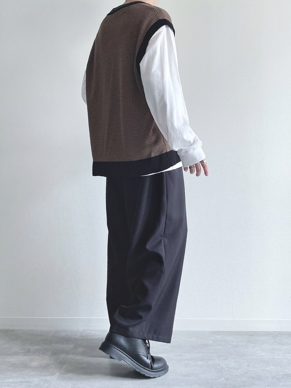 ホワイト系のTシャツ/カットソー、ブラウン系のトップス、ブラック系のスラックスを着用したメンズの秋コーディネートの4枚目の写真