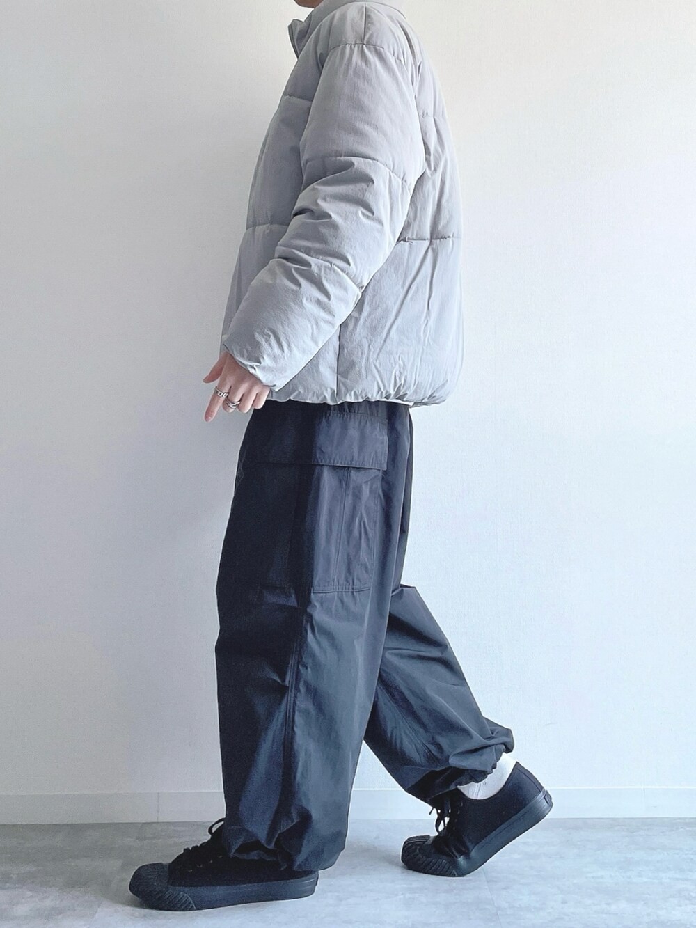 グレー系のダウンジャケット/コート、ホワイト系のトップス、ブラック系のカーゴパンツを着用したメンズの冬コーディネートの3枚目の写真