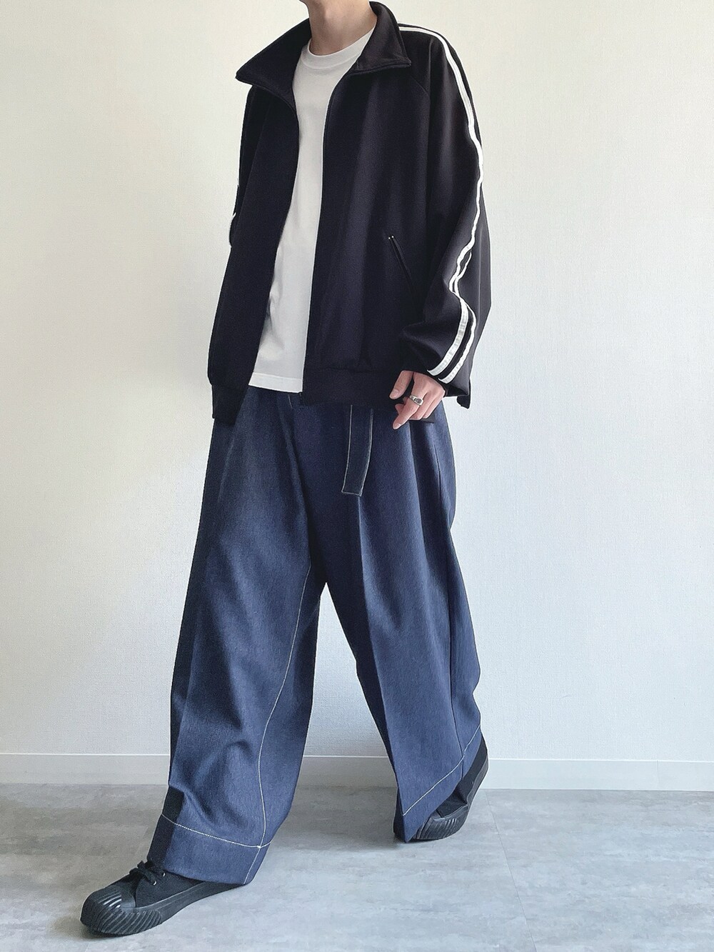 ブラック系のブルゾン、ホワイト系のTシャツ/カットソー、ブルー系のデニムパンツを着用したメンズの春コーディネートの5枚目の写真
