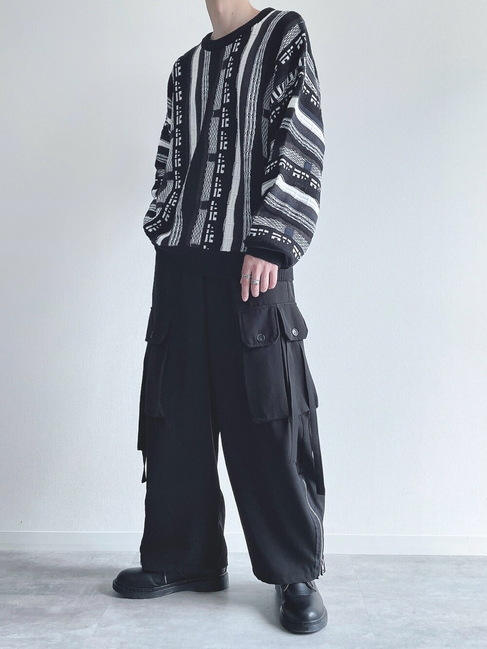 ブラック系のニット/セーター、ブラック系のカーゴパンツ、ブラック系のスニーカーを着用したメンズの秋コーディネートの5枚目の写真