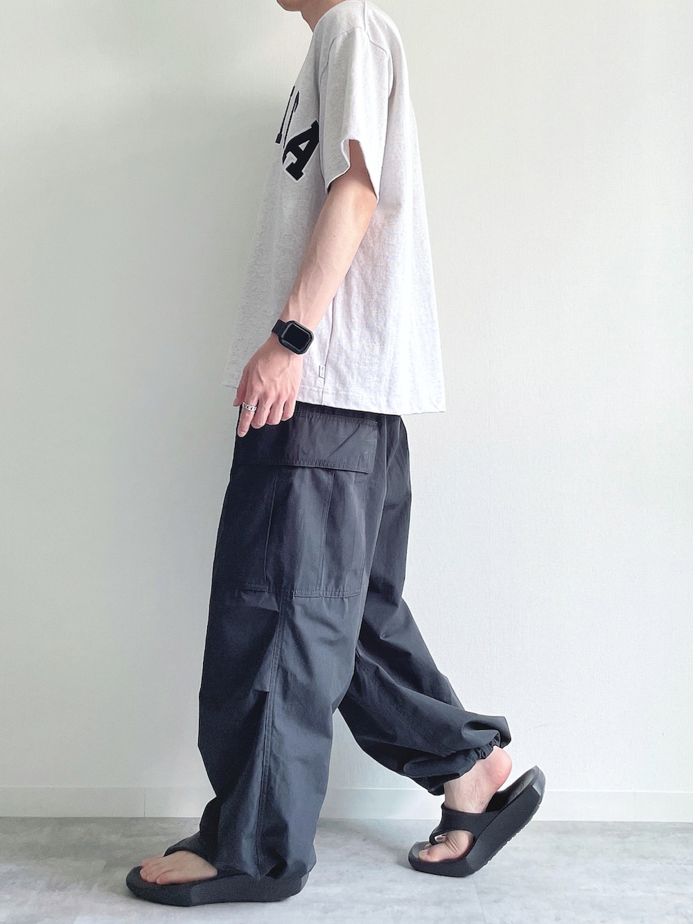 グレー系のTシャツ/カットソー、ブラック系のカーゴパンツ、ブラック系のサンダルを着用したメンズの夏コーディネートの3枚目の写真