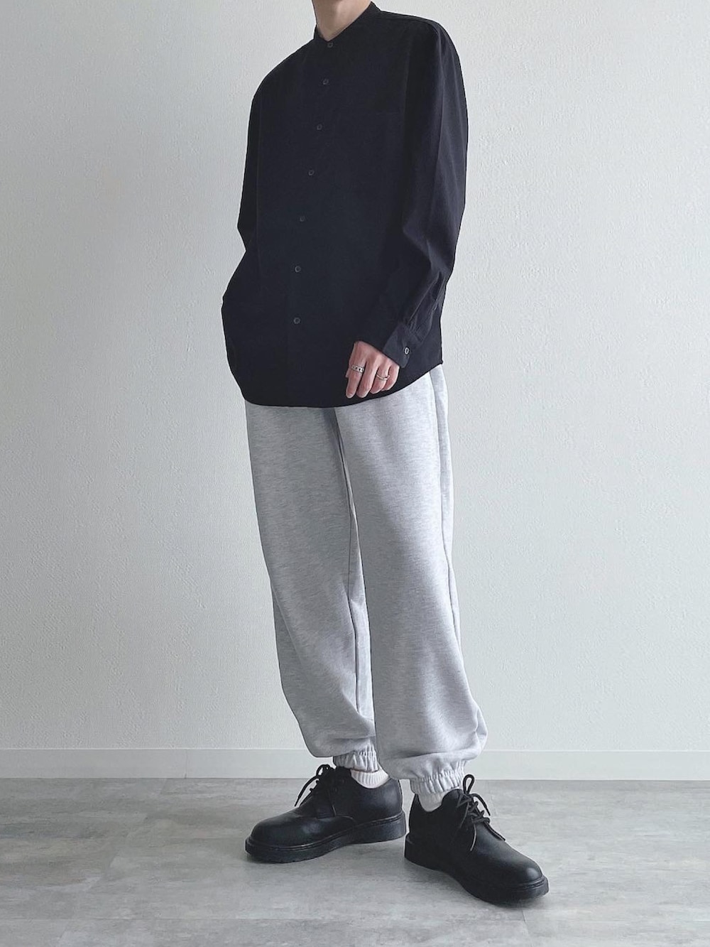 ブラック系のトップス、グレー系のスウェットパンツ、ブラック系のドレスシューズを着用したメンズの秋コーディネートの2枚目の写真