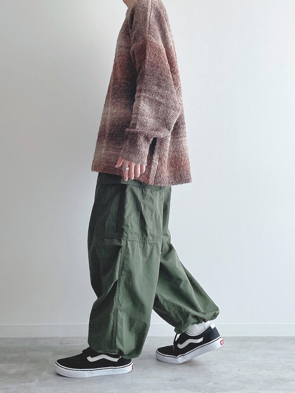 ブラウン系のニット/セーター、グリーン系のカーゴパンツ、ブラック系のスニーカーを着用したメンズの秋コーディネートの2枚目の写真