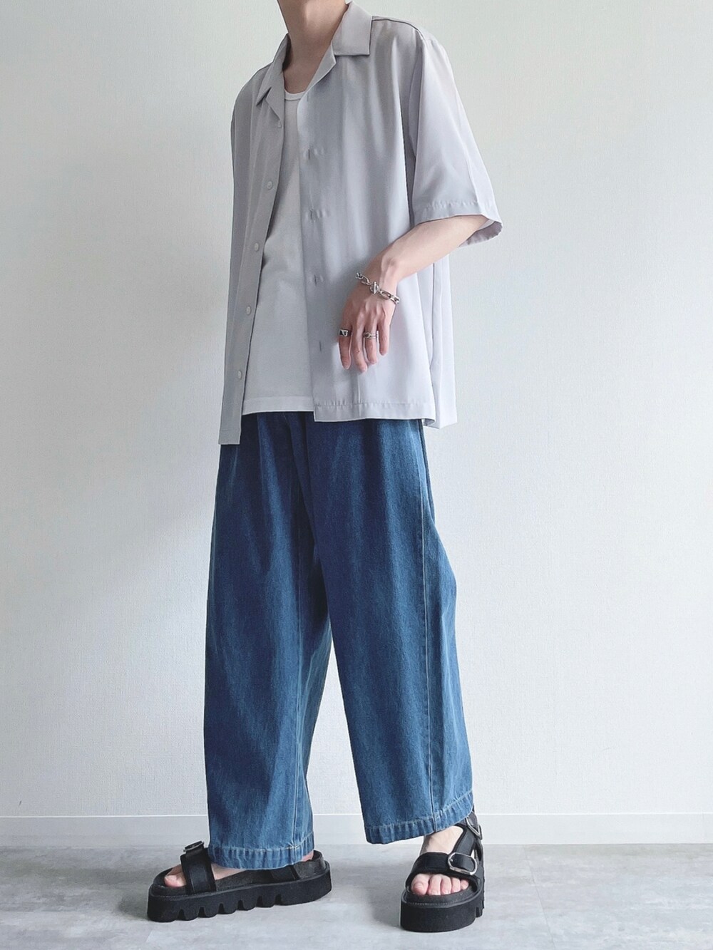 グレー系のトップス、ホワイト系のタンクトップ、ブルー系のデニムパンツを着用したメンズの夏コーディネートの3枚目の写真