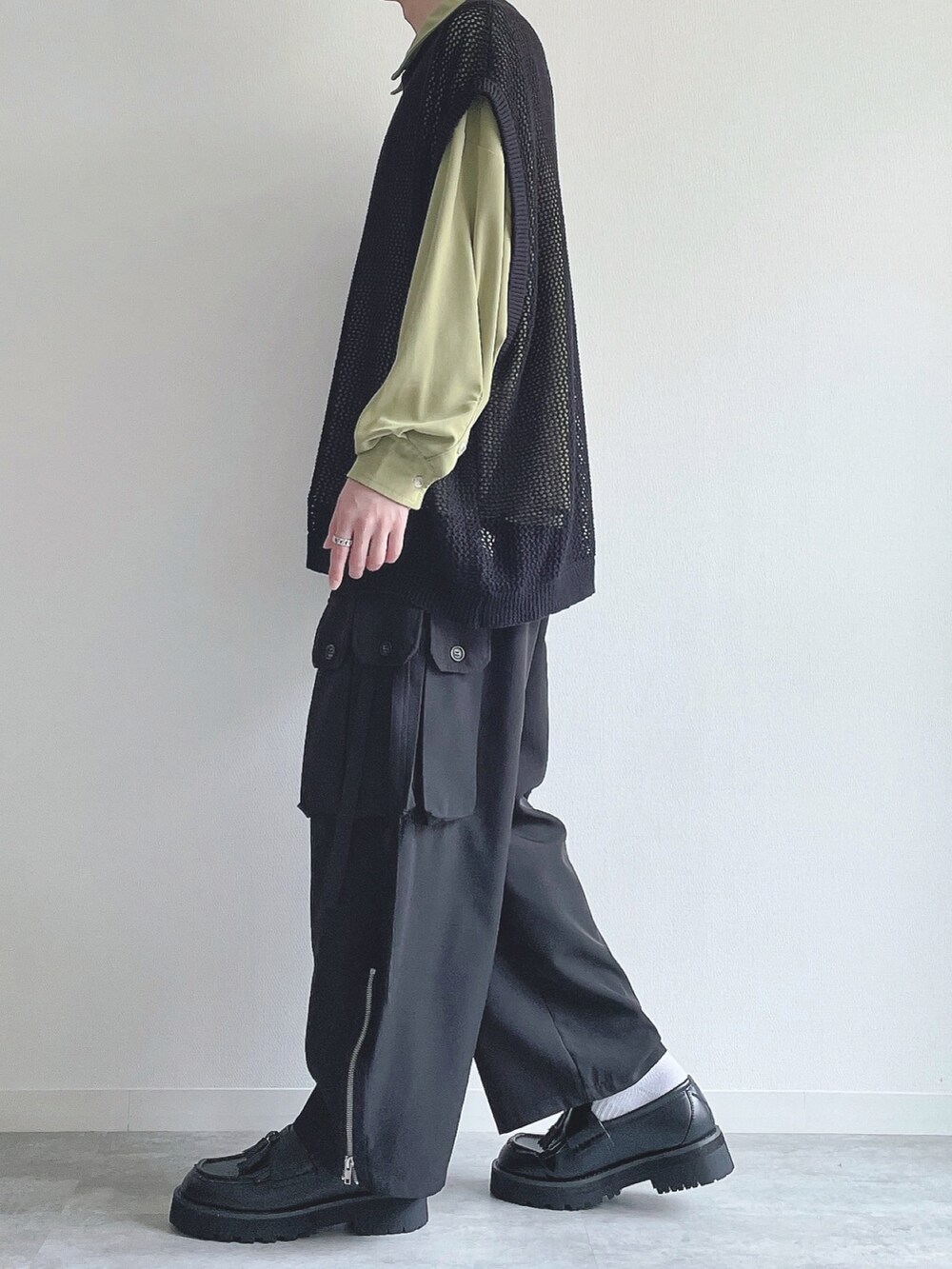 グリーン系のシャツ/ブラウス、ブラック系のベスト、ブラック系のカーゴパンツを着用したメンズの春コーディネートの2枚目の写真