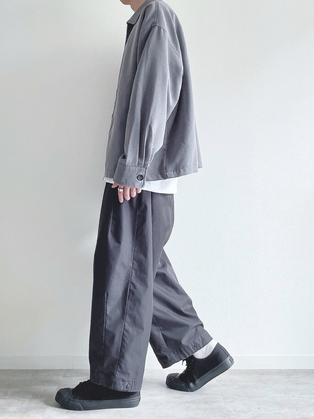 グレー系のブルゾン、ホワイト系のTシャツ/カットソー、ブラック系のその他パンツを着用したメンズの秋コーディネートの3枚目の写真