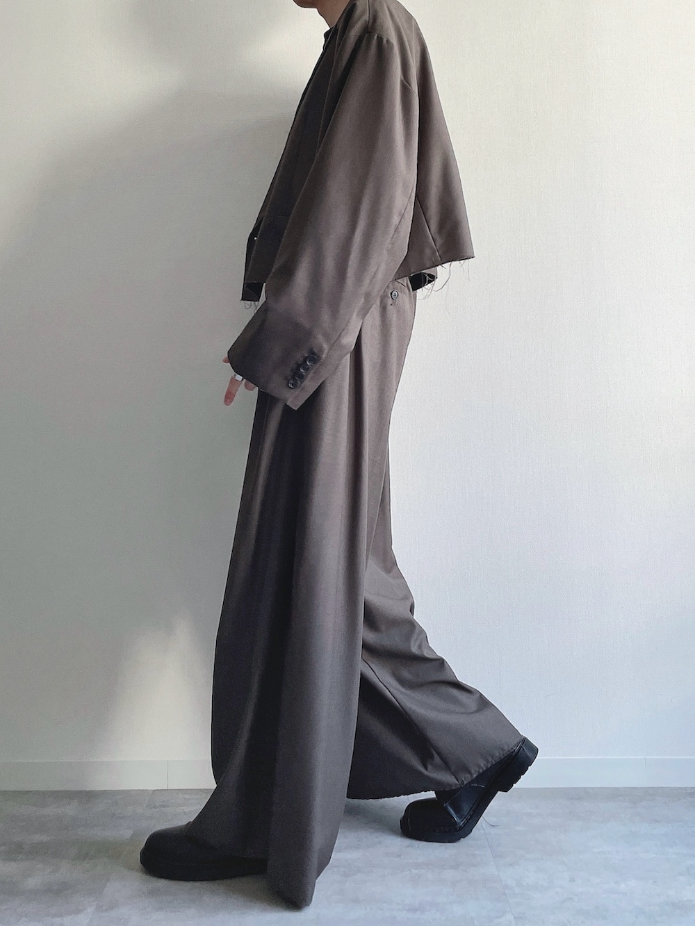 ベージュ系のテーラードジャケット、ベージュ系のスラックス、ブラック系のTシャツ/カットソーを着用したメンズの冬コーディネートの3枚目の写真