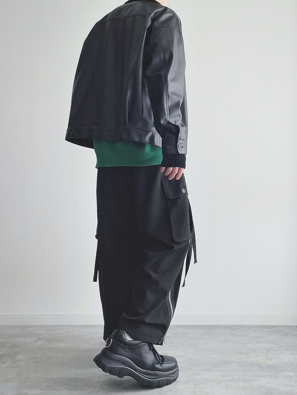 ブラック系のブルゾン、グリーン系のトップス、ブラック系のカーゴパンツを着用したメンズの秋コーディネートの3枚目の写真