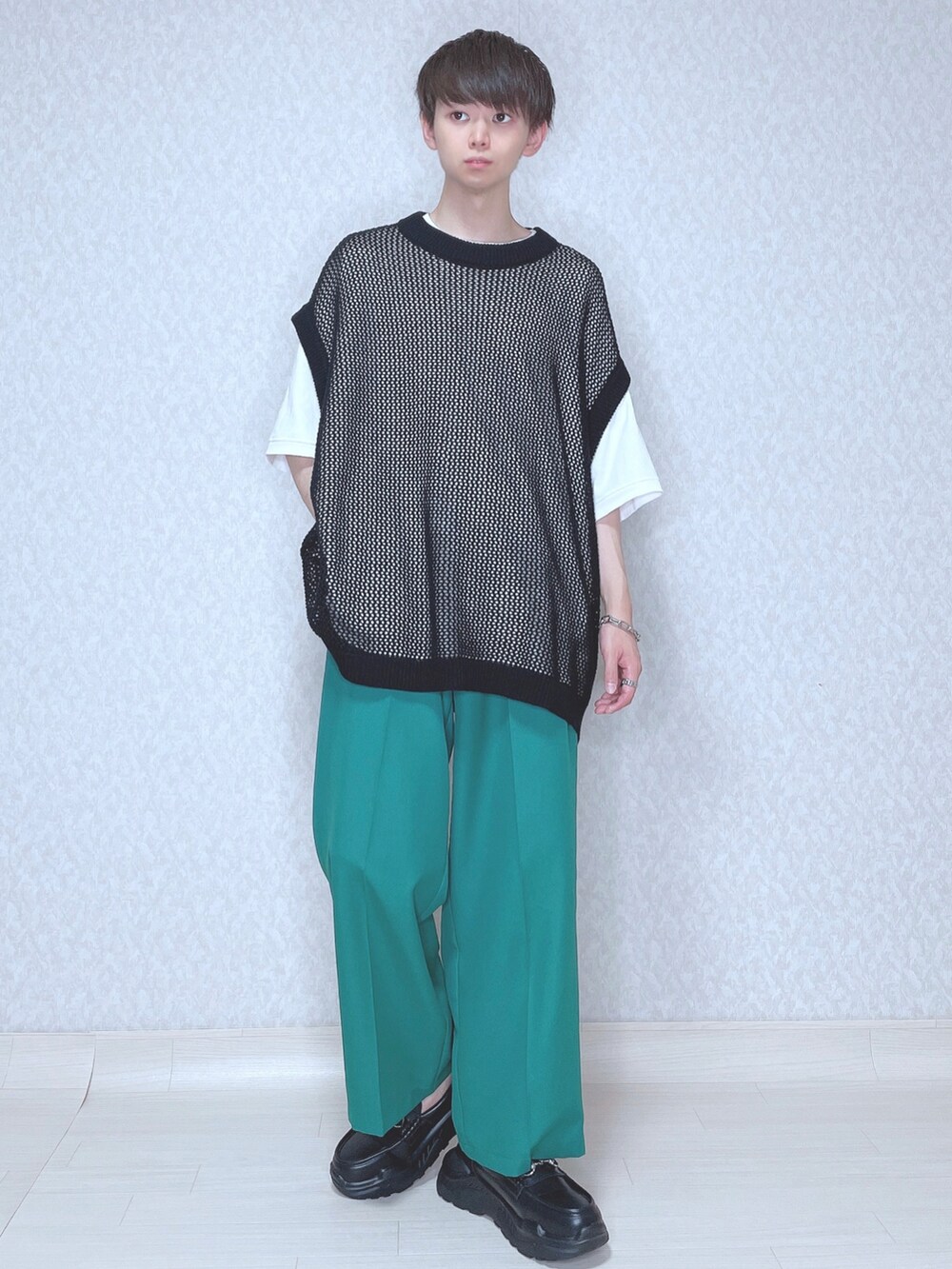 ブラック系のベスト、ホワイト系のTシャツ/カットソー、グリーン系のスラックスを着用したメンズの夏コーディネートの2枚目の写真