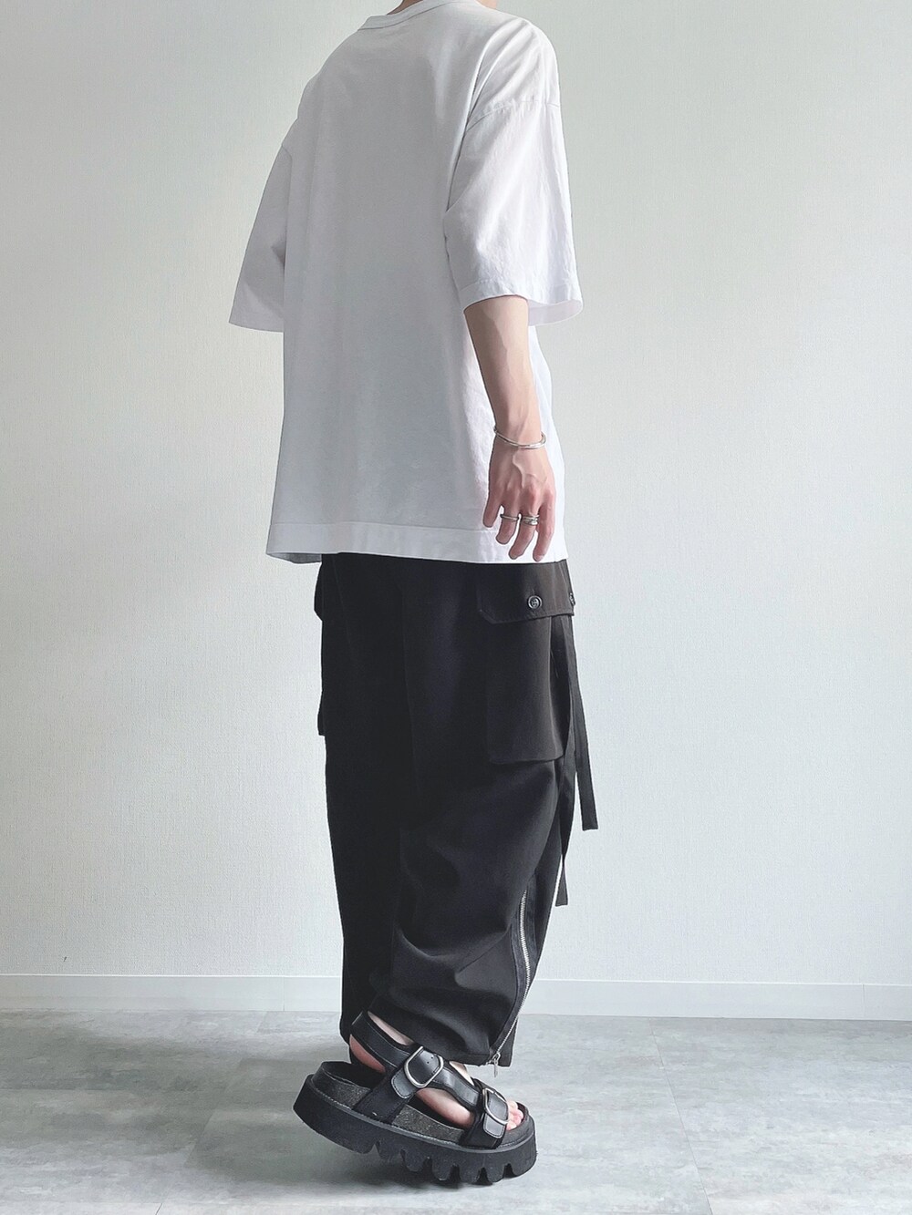 ホワイト系のTシャツ/カットソー、ブラック系のカーゴパンツ、ブラック系のサンダルを着用したメンズの夏コーディネートの4枚目の写真