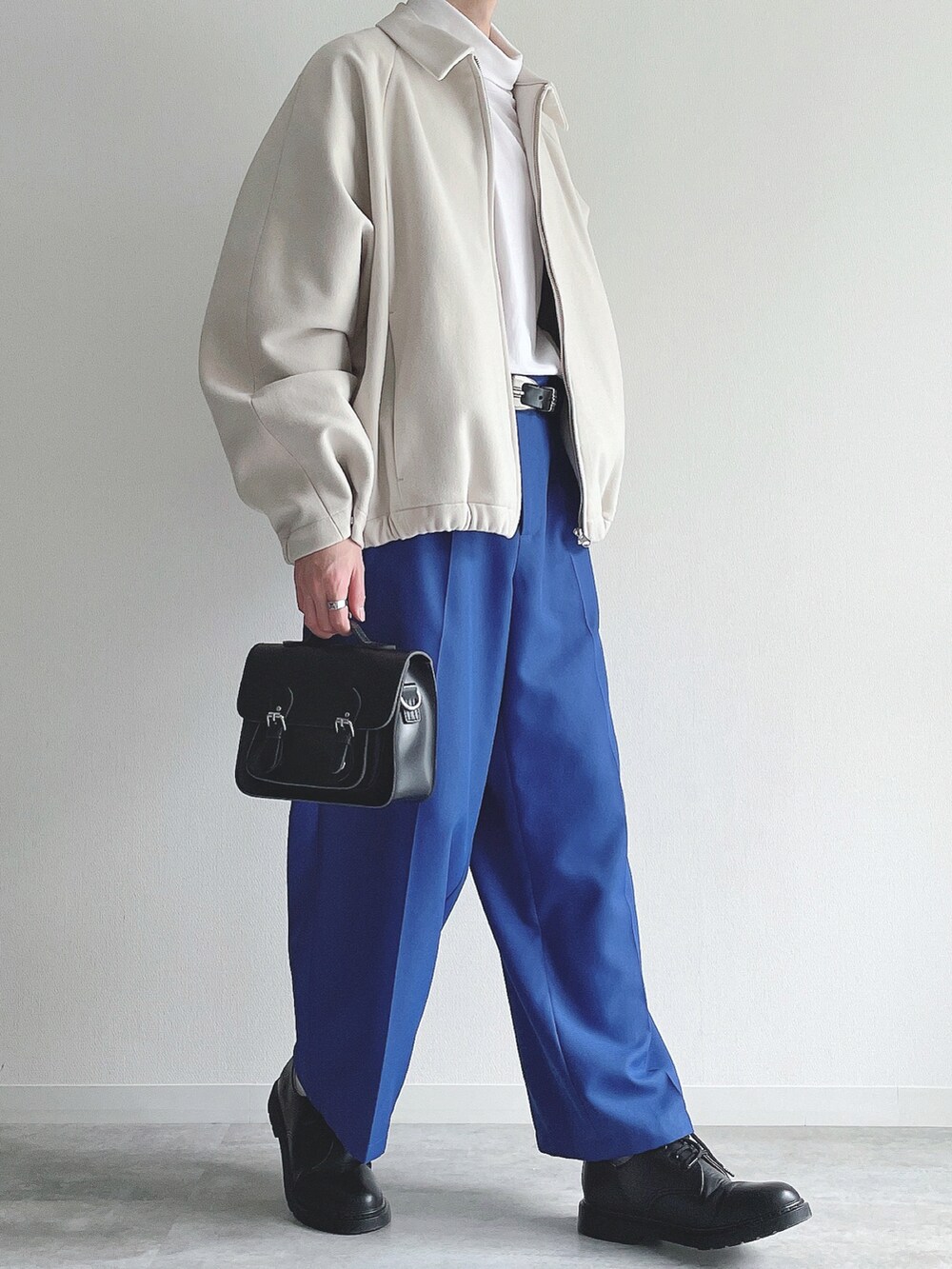 ホワイト系のブルゾン、ホワイト系のTシャツ/カットソー、ブルー系のスラックスを着用したメンズの冬コーディネートの5枚目の写真