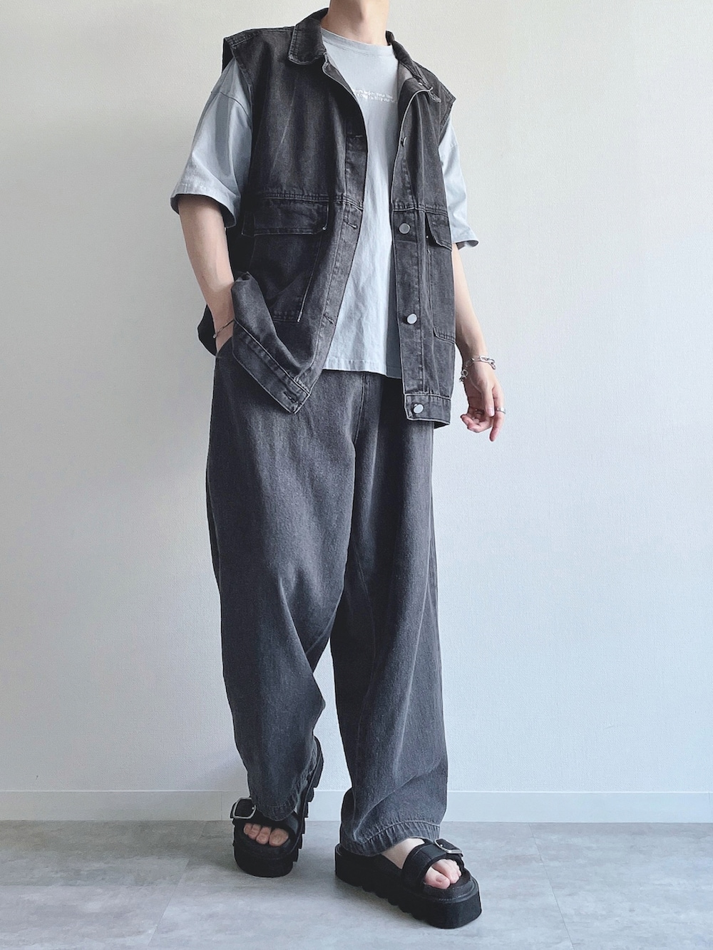 ブラック系のベスト、ブルー系のTシャツ/カットソー、ブラック系のデニムパンツを着用したメンズの夏コーディネートの3枚目の写真