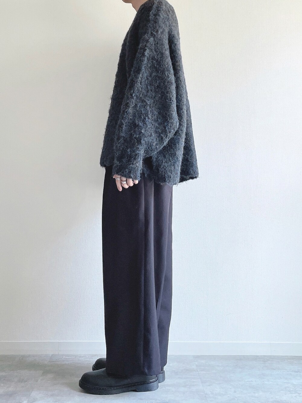 ブルー系のニット/セーター、ブラック系のスラックス、ブラック系のシューズを着用したメンズの秋コーディネートの3枚目の写真