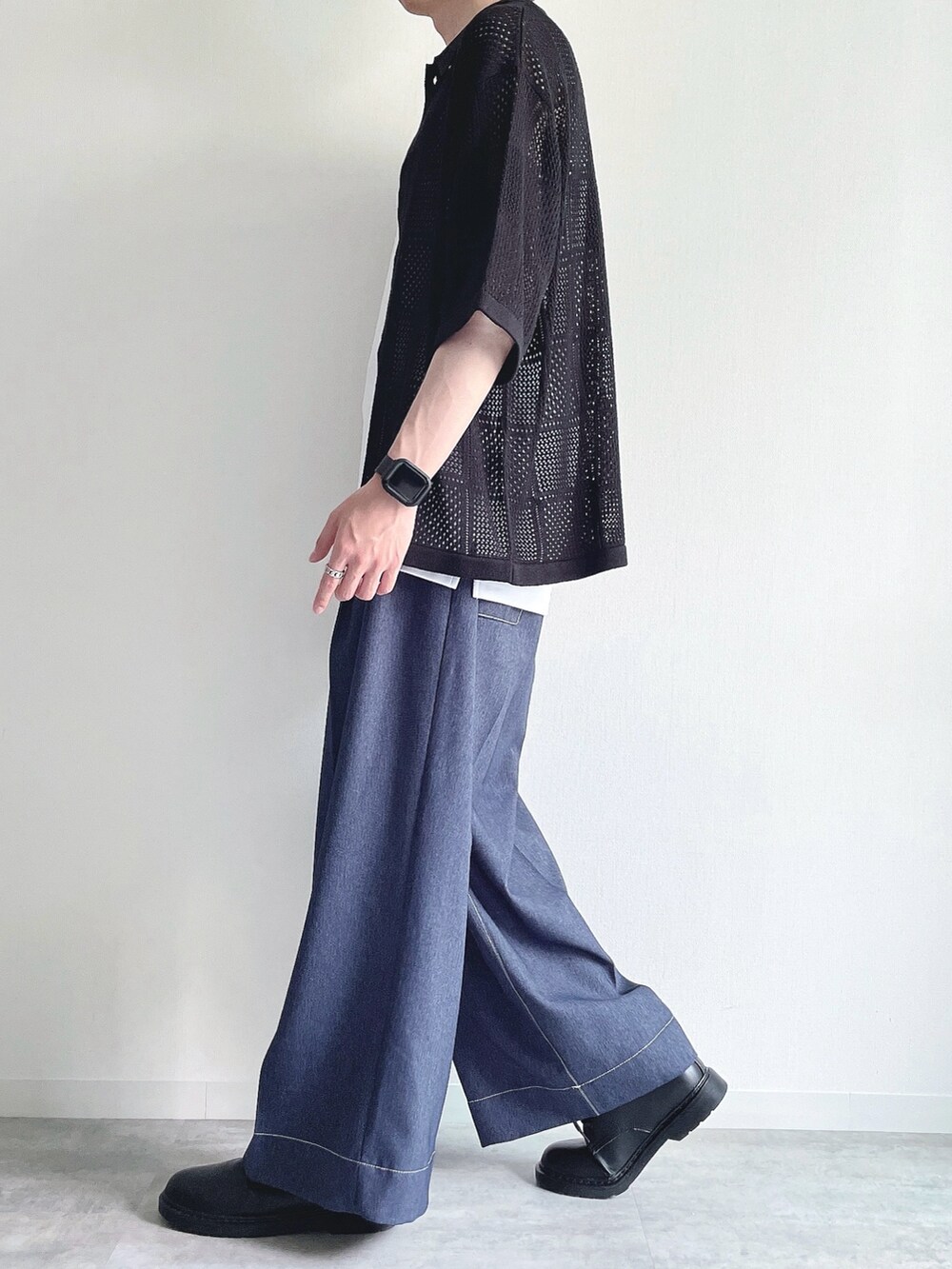 ブラック系のトップス、ホワイト系のタンクトップ、ブルー系のデニムパンツを着用したメンズの夏コーディネートの3枚目の写真