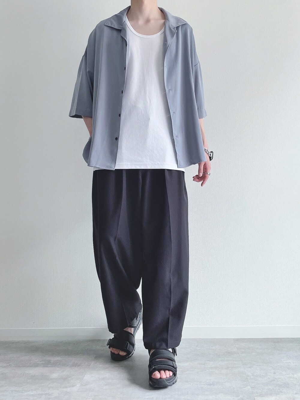 ブルー系のシャツ/ブラウス、ホワイト系のタンクトップ、ブラック系のスラックスを着用したメンズの夏コーディネートの2枚目の写真