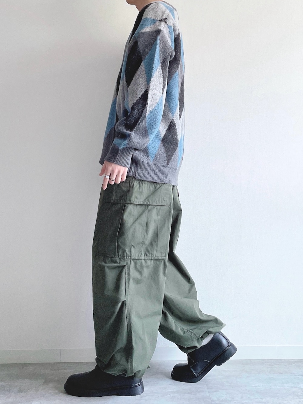 グレー系のカーディガン/ボレロ、ホワイト系のTシャツ/カットソー、グリーン系のカーゴパンツを着用したメンズの冬コーディネートの3枚目の写真