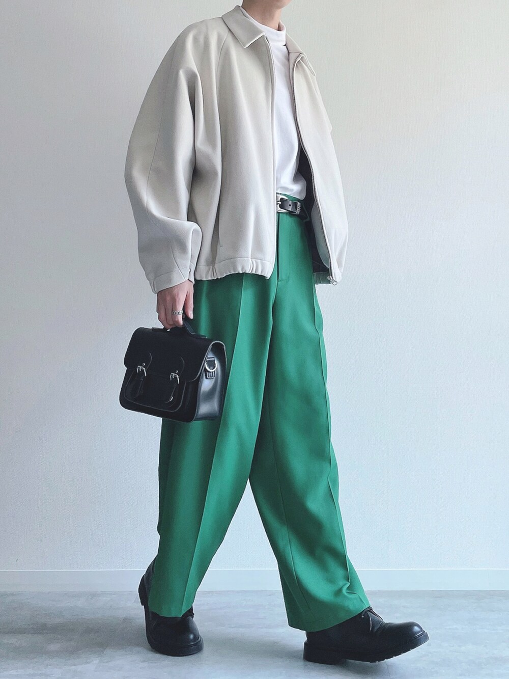 ホワイト系のブルゾン、ホワイト系のTシャツ/カットソー、グリーン系のスラックスを着用したメンズの春コーディネートの5枚目の写真