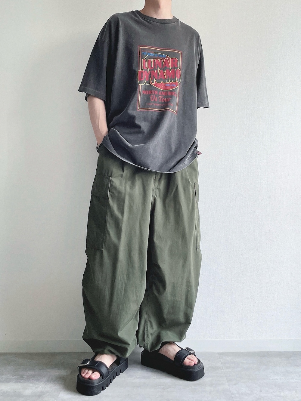 グレー系のTシャツ/カットソー、グリーン系のカーゴパンツ、ブラック系のサンダルを着用したメンズの夏コーディネートの5枚目の写真