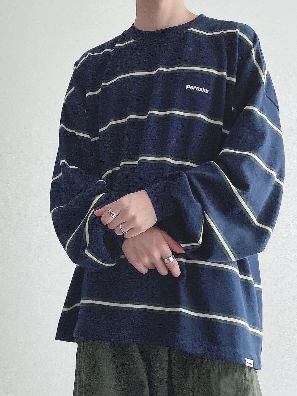 ブルー系のTシャツ/カットソー、グリーン系のカーゴパンツ、ブラック系のスニーカーを着用したメンズの秋コーディネートの4枚目の写真