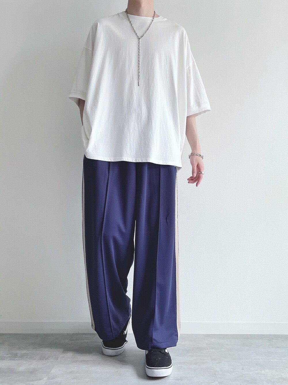 ホワイト系のTシャツ/カットソー、ブルー系のその他パンツ、ブラック系のスニーカーを着用したメンズの夏コーディネートの2枚目の写真