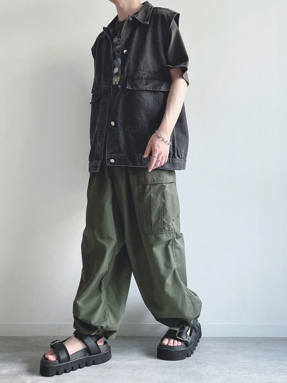 ブラック系のベスト、ブラック系のTシャツ/カットソー、グリーン系のカーゴパンツを着用したメンズの夏コーディネートの5枚目の写真