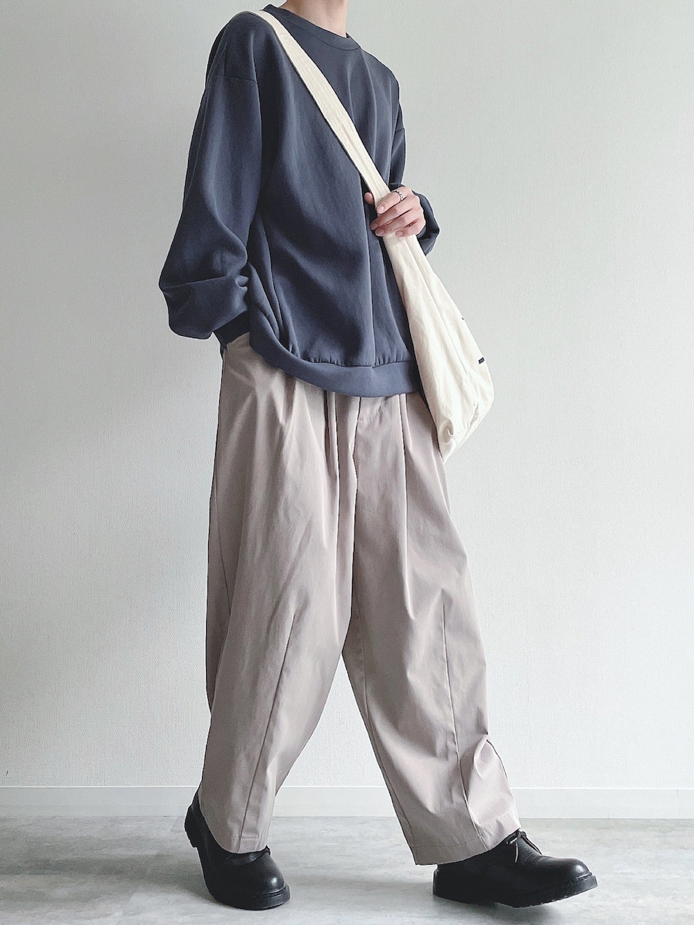 ブルー系のトップス、ベージュ系のその他パンツ、ブラック系のドレスシューズを着用したメンズの冬コーディネートの5枚目の写真