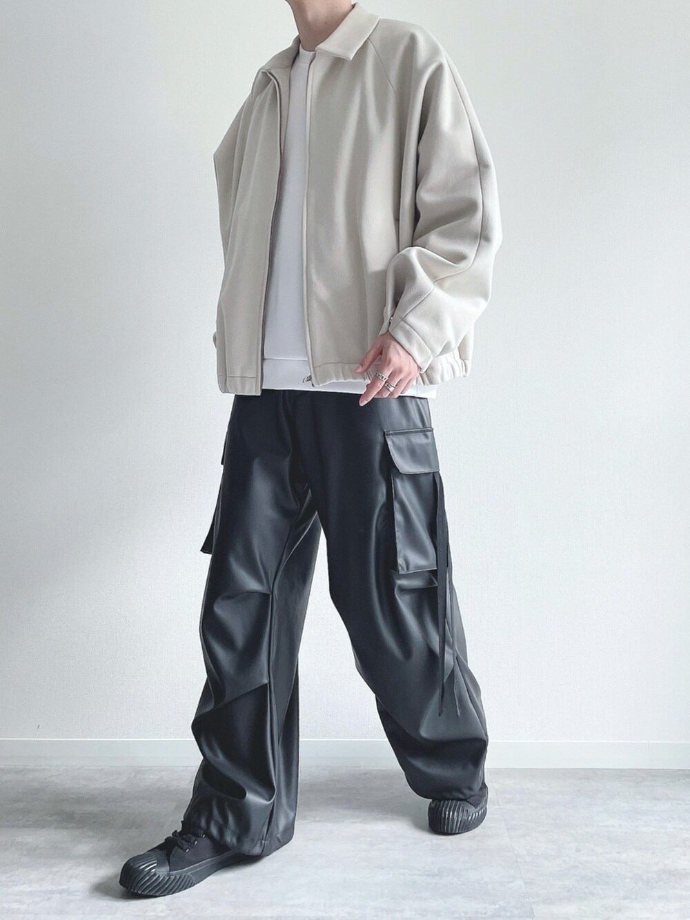 ホワイト系のブルゾン、ホワイト系のトップス、ブラック系のカーゴパンツを着用したメンズの冬コーディネートの5枚目の写真