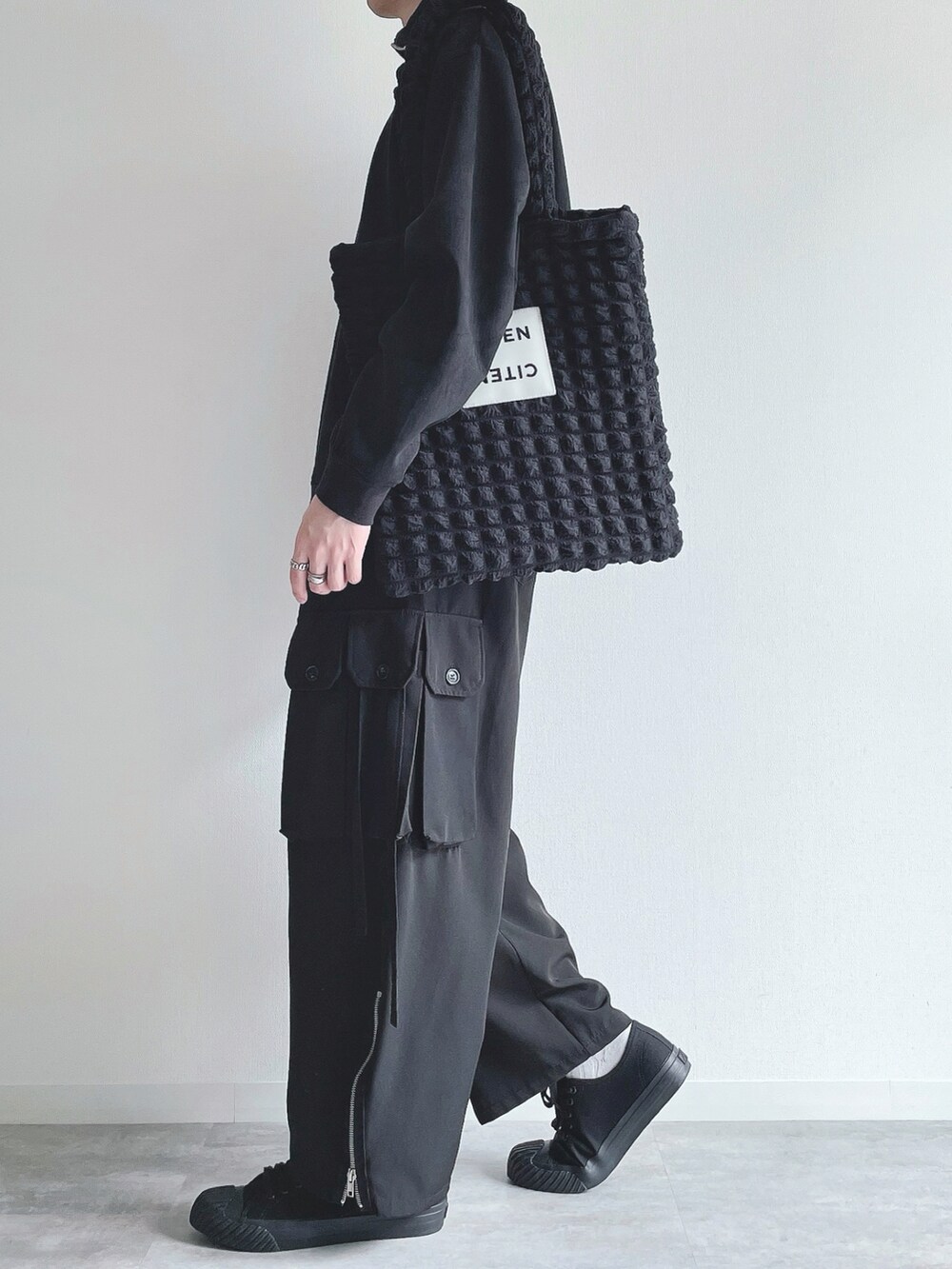 ブラック系のスウェット、ブラック系のカーゴパンツ、ブラック系のスニーカーを着用したメンズの冬コーディネートの3枚目の写真