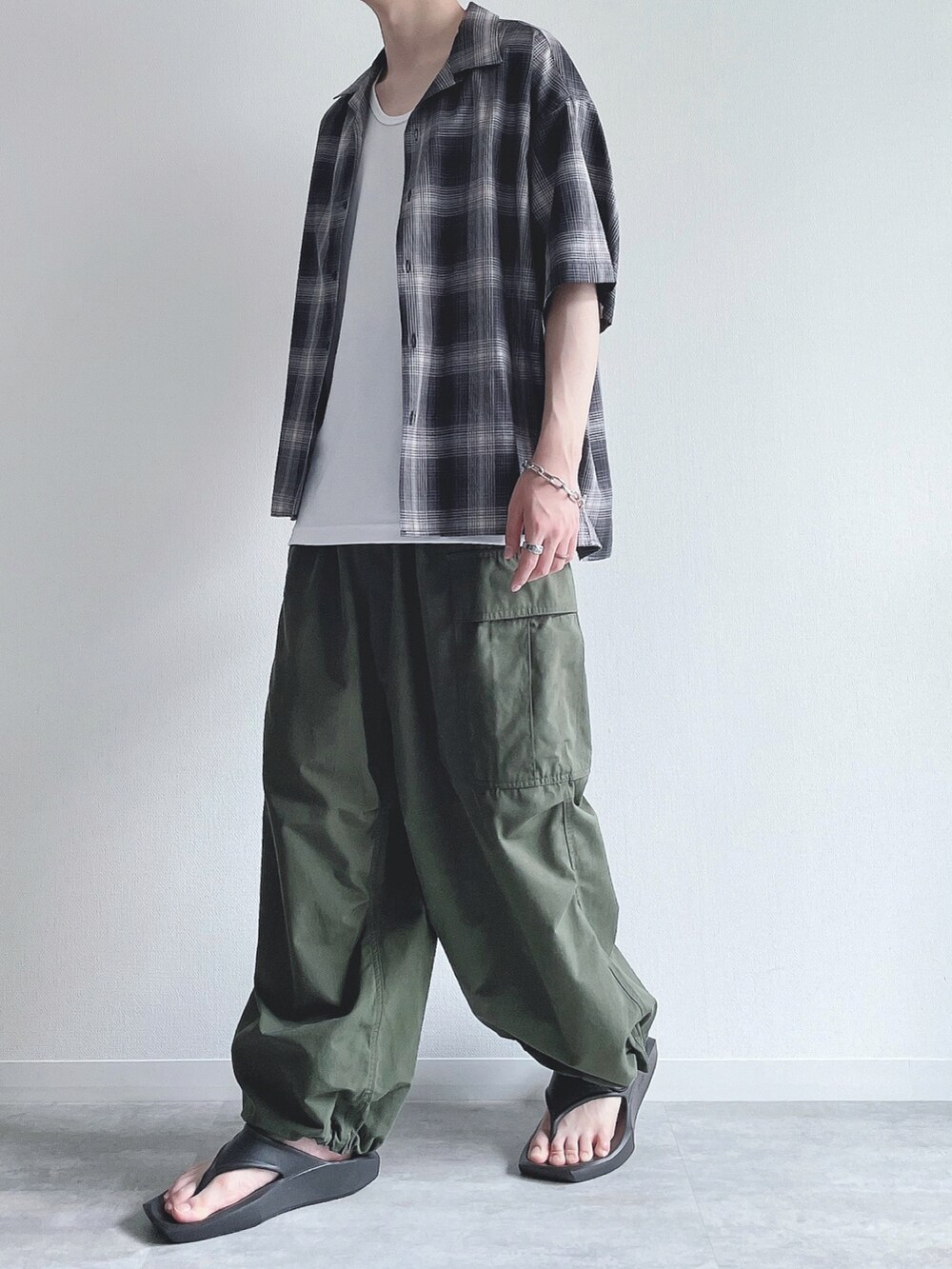 ブラック系のシャツ/ブラウス、ホワイト系のタンクトップ、グリーン系のカーゴパンツを着用したメンズの夏コーディネートの5枚目の写真