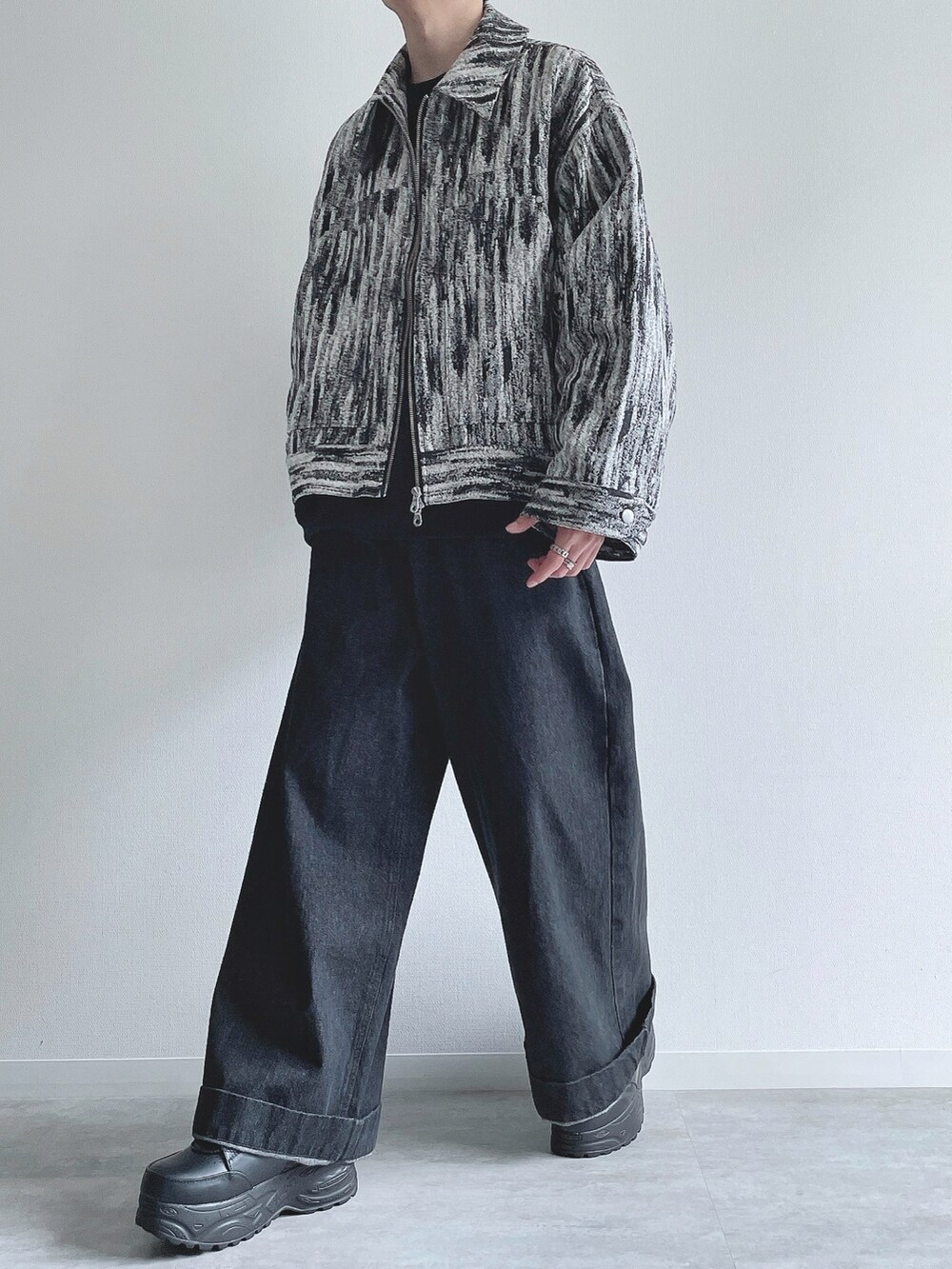 ホワイト系のブルゾン、ブラック系のトップス、ブラック系のデニムパンツを着用したメンズの冬コーディネートの5枚目の写真